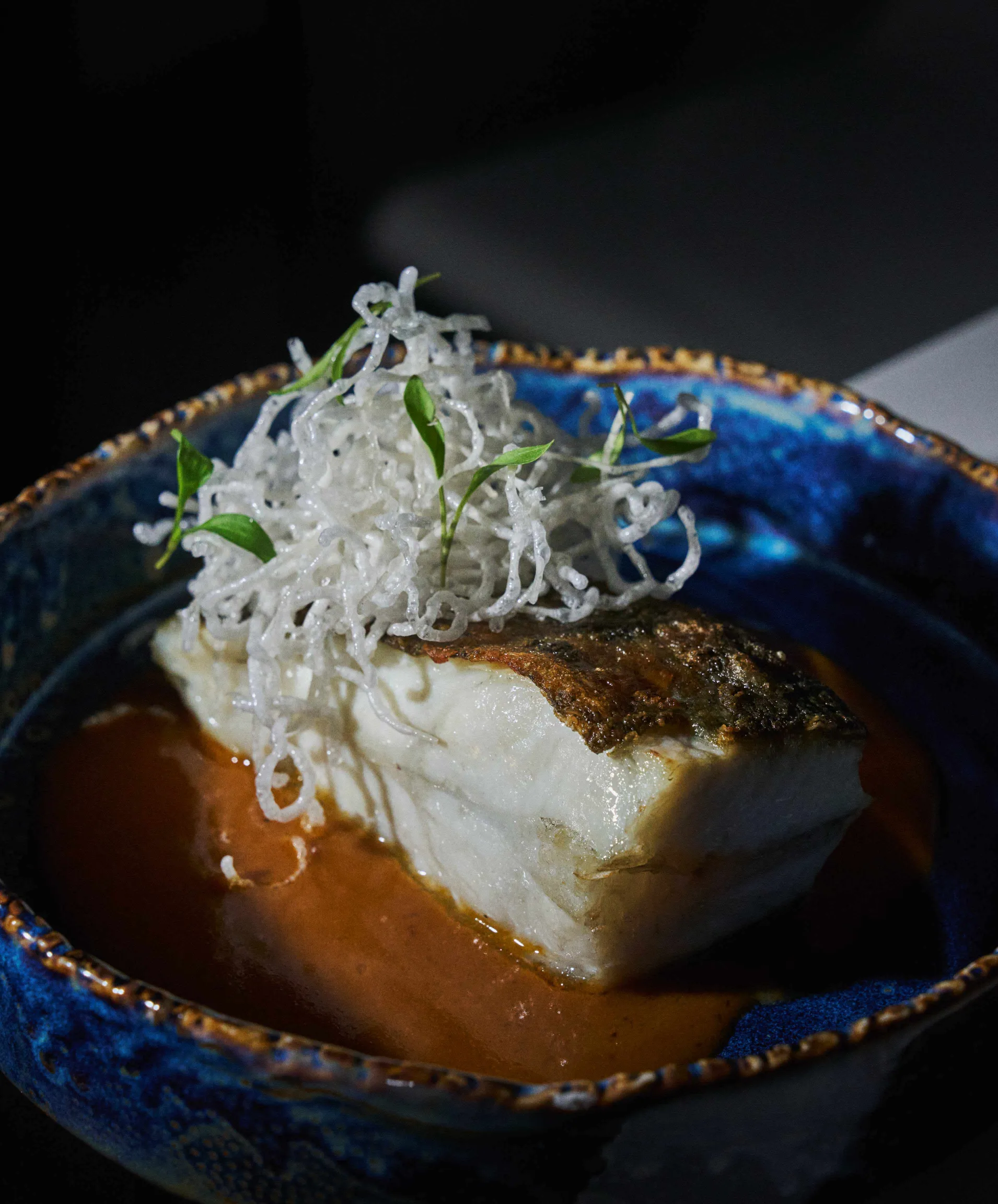Pescado con piel crujiente a la plancha, salsa amarilla y verduras de temporada en plato gourmet, alta cocina creativa